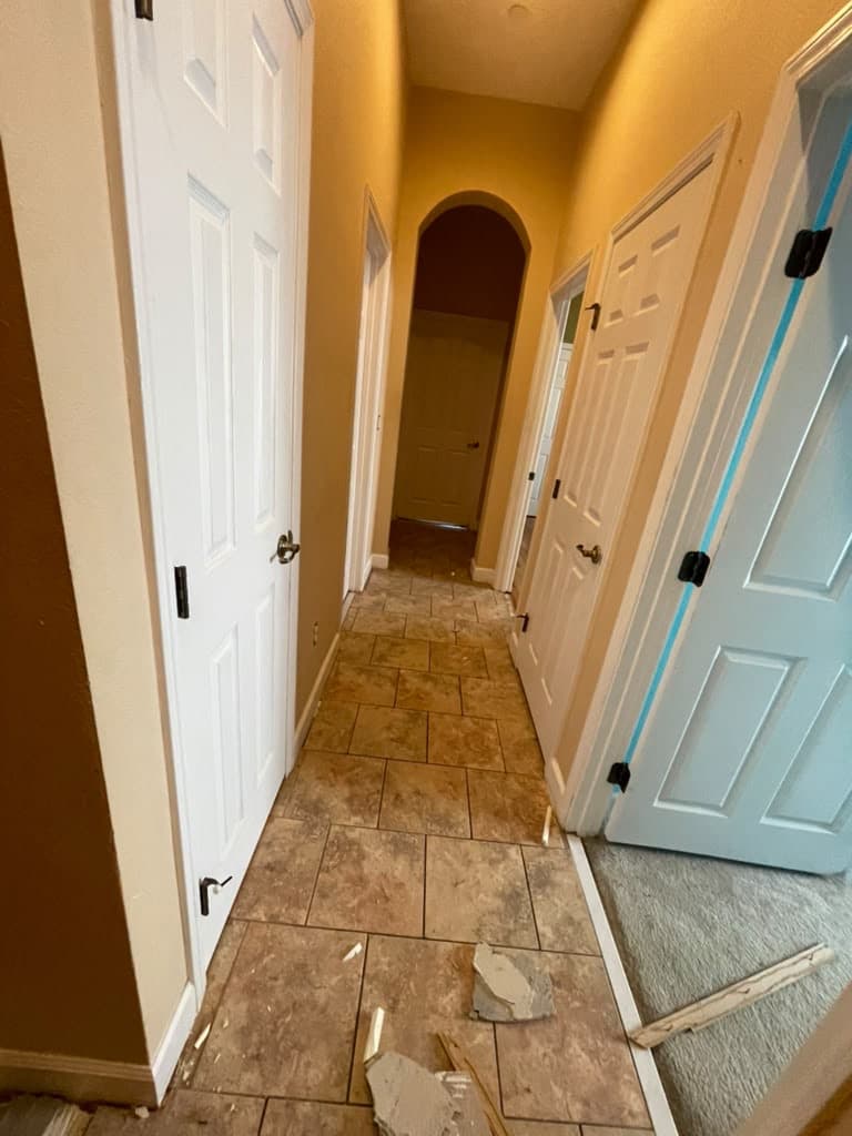The same hallway before the project, with beige tile partly removed