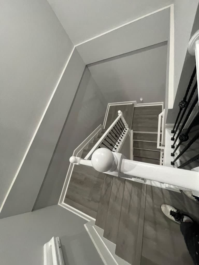 Staircase and landing with new gray flooring and white risers, seen from above