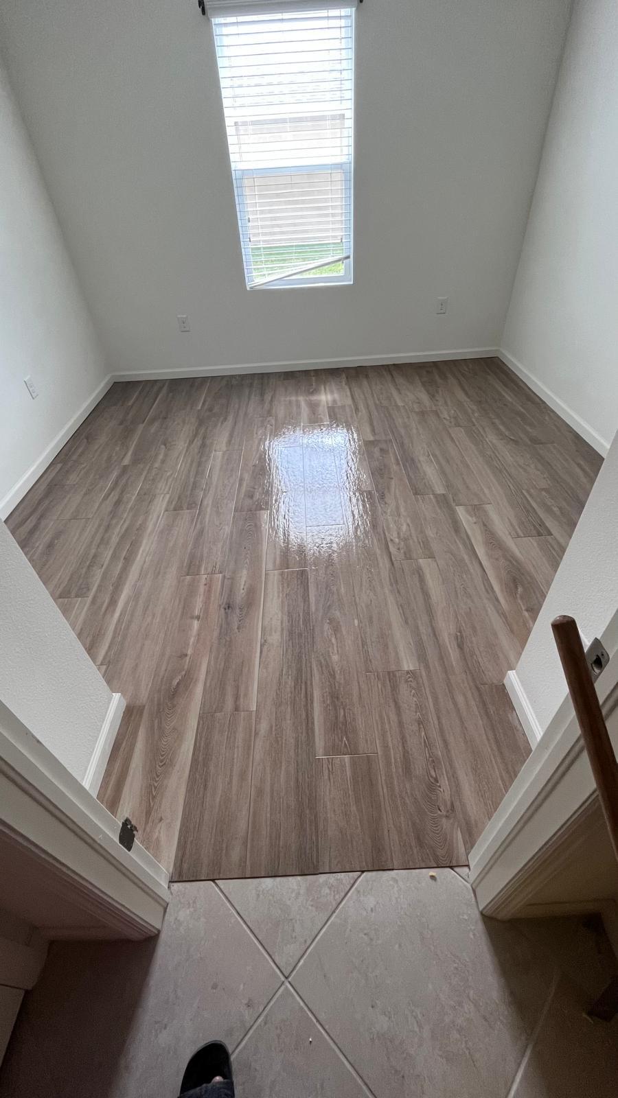 Small room with new wood-look flooring under a window